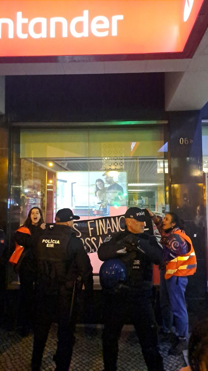 8M: Apoiantes do Climáximo estilhaçam os vidros do Santander. Polícia libertou as ativistas sob pressão popular